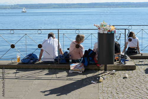Fotografie Tourists and garbage on a sunny lake
