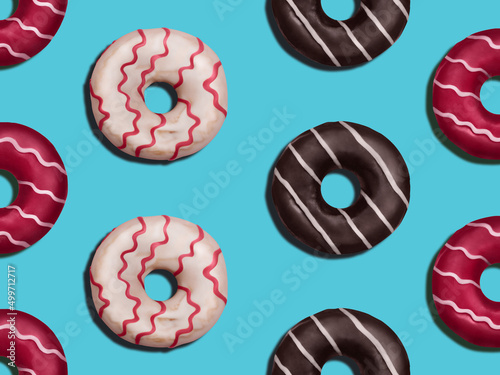Donuts. Flat lay photo pattern. Various colorful glazed donuts on blue backdrop