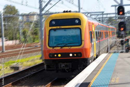 Commuter train approaching at a train station in Sydney NSW Australia blurred background 