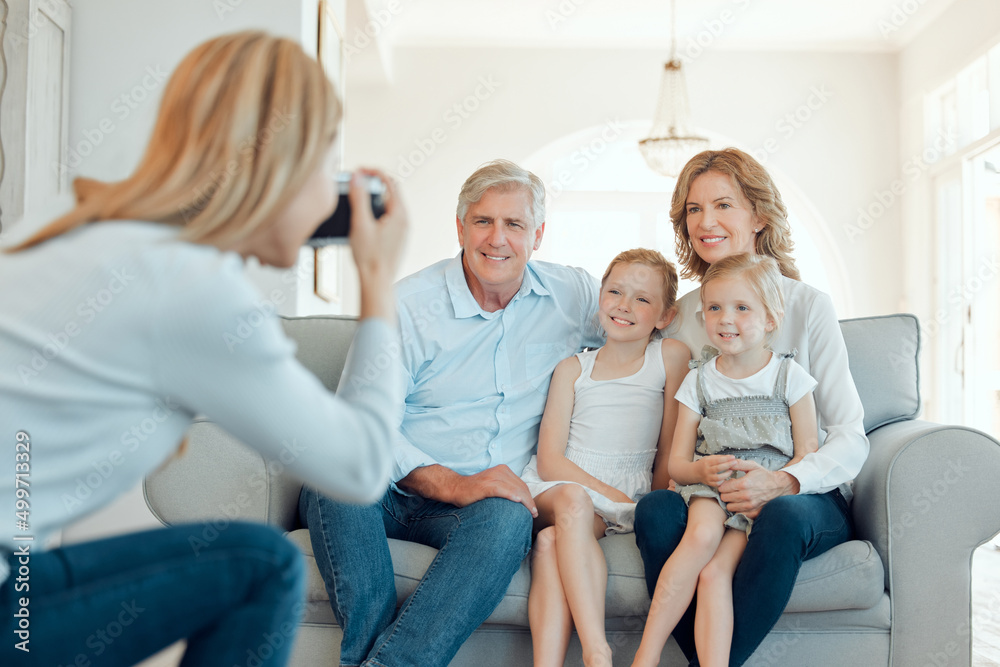Hold that pose. Shot of grandparents bonding with their grandchildren on a sofa at home and getting their picture taken. Hold that pose. Shot of grandparents bonding with their grandchildren on a sofa at home and getting their picture taken.