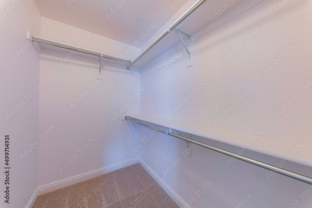 Walk-in closet with wall-mounted shelves with brackets and metal rods