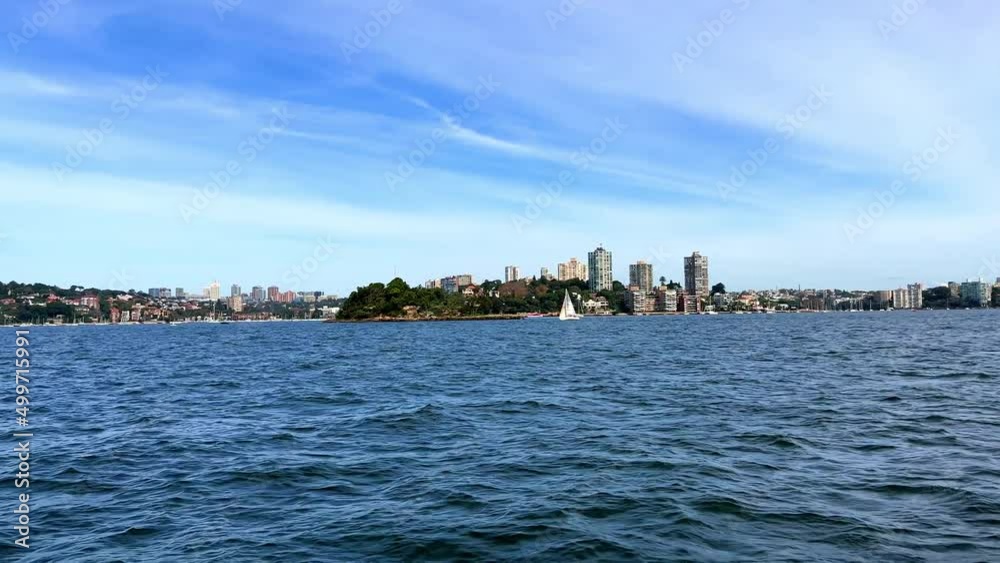 Sydney Harbour foreshore on a party cloudy sky. viewed from ferry on way to Many, you can see apartments, wealthy luxury houses, yachts boats beaches and cliffs NSW Australia Sydney Harbour foreshore on a party cloudy sky. viewed from ferry on way to Many, you can see apartments, wealthy luxury houses, yachts boats beaches and cliffs NSW Australia