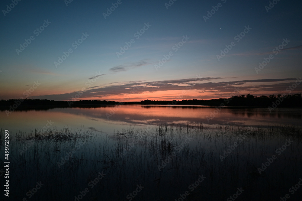 Sunrise cloudscape reflected in calm water of Nine Mile Pond in Everglades National Park, Florida in April. Sunrise cloudscape reflected in calm water of Nine Mile Pond in Everglades National Park, Florida in April.