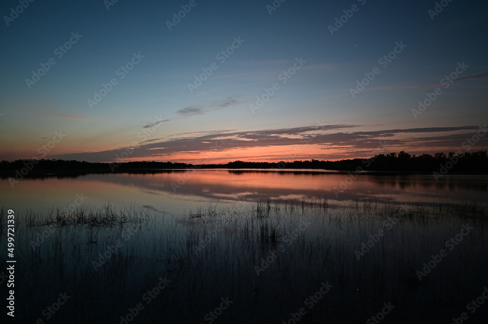 Sunrise cloudscape reflected in calm water of Nine Mile Pond in Everglades National Park, Florida in April.