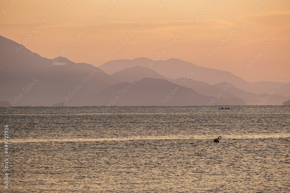 view of the sea and mountains in the distance at dawn