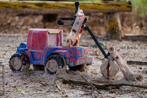 plastic toy car damaged and abandoned in sand
