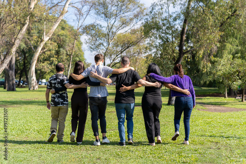 Wallpaper Mural Multi ethnic family group walking arm in arm in a park. Family, group, teamwork, friendship concept Torontodigital.ca