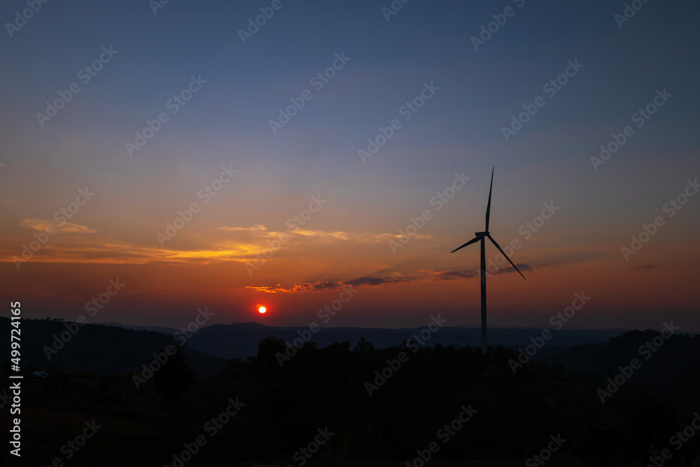 Obraz premium Wind turbine farm on mountain landscape at sunset sky background. Wind power renewable energy concept.