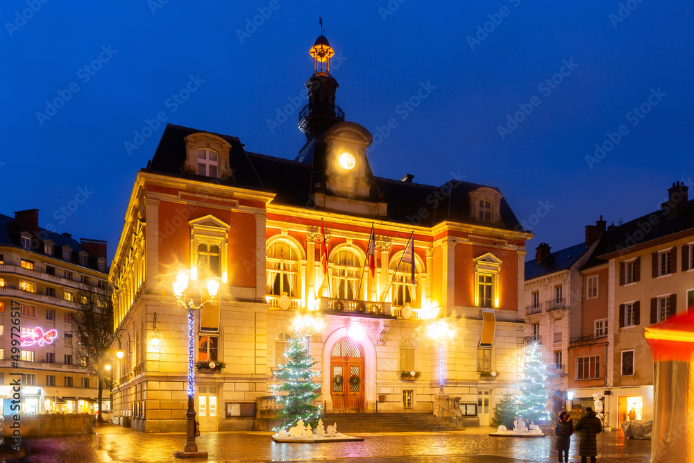 Fototapeta premium Scenic night view of Chambery town hall in central square during winter Christmas season with bright lighting and traditional decorations, France