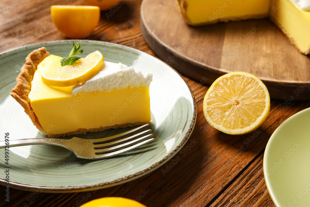 Plate with piece of tasty lemon pie on wooden background Plate with piece of tasty lemon pie on wooden background