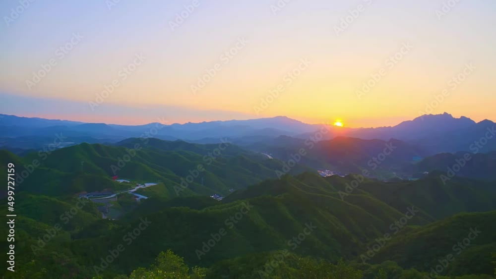 Time-lapse aerial view of the sun slowly rising, spring breeze blowing over the mountains Time-lapse aerial view of the sun slowly rising, spring breeze blowing over the mountains