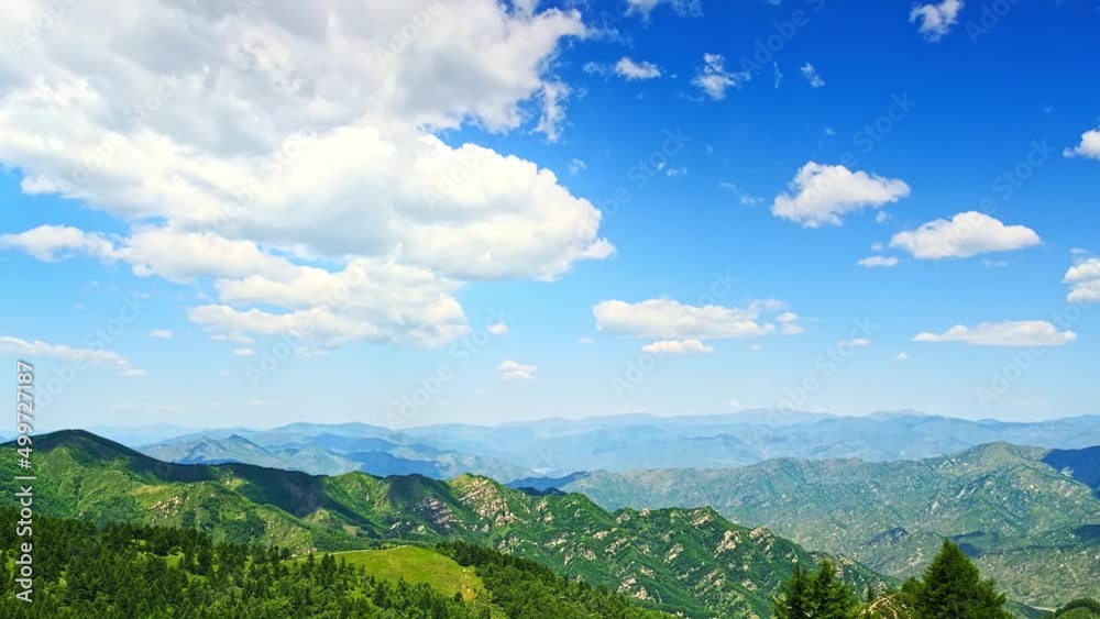 Time lapse, white clouds rolling in blue sky and shadows on the top of mountains Time lapse, white clouds rolling in blue sky and shadows on the top of mountains