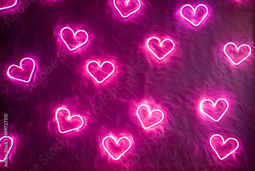 Neon pink heart on white fur. Valentine's day background