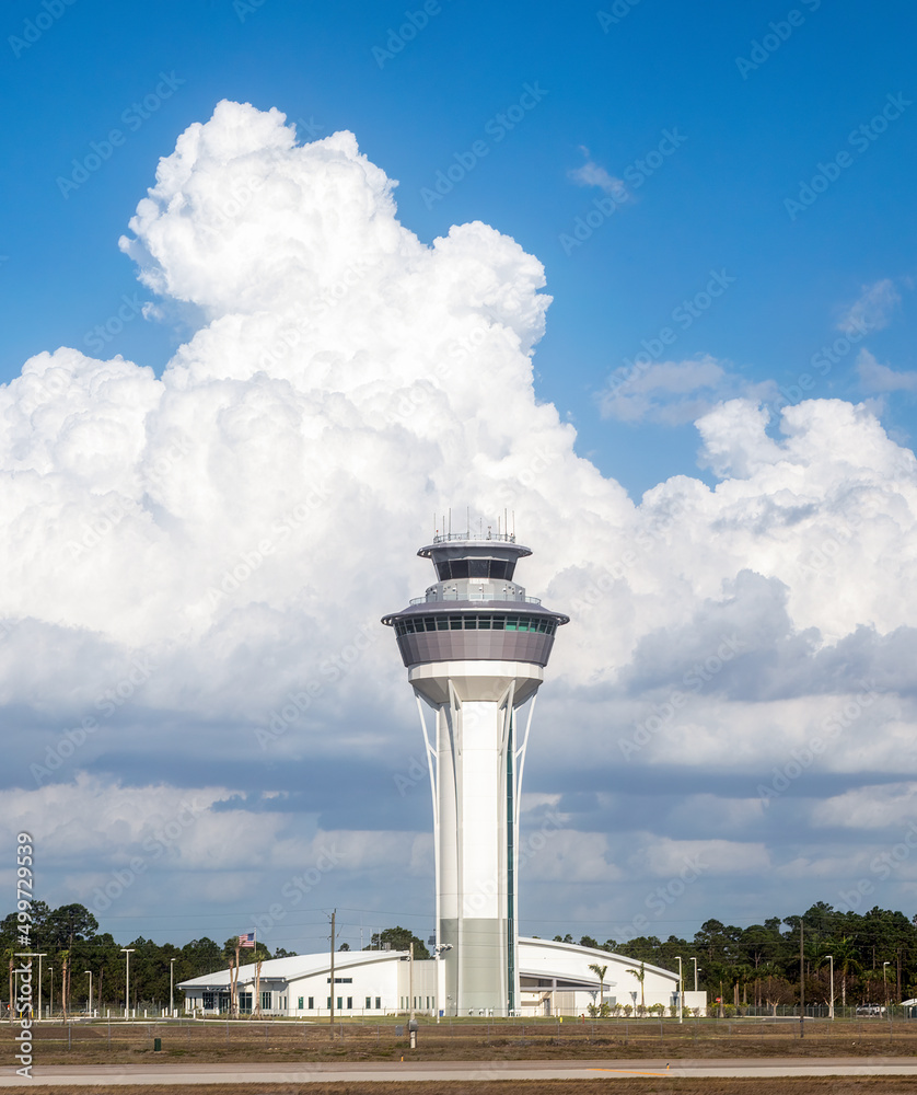 Built in 2021, the air traffic control tower at Southwest Florida International Airport in Fort Myers rises 225 feet above the runways backed by towering clouds in a blue sky.