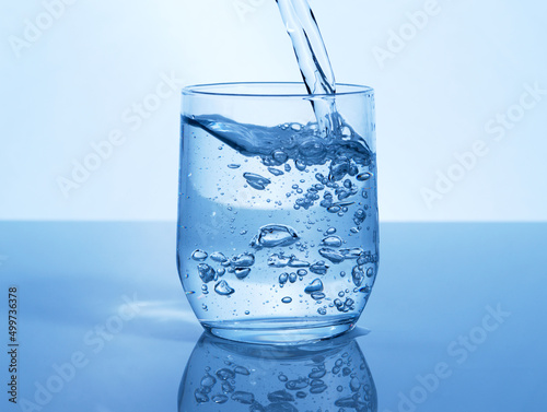 A glass of water can do the world of good. Studio shot of a glass of water being poured in studio.