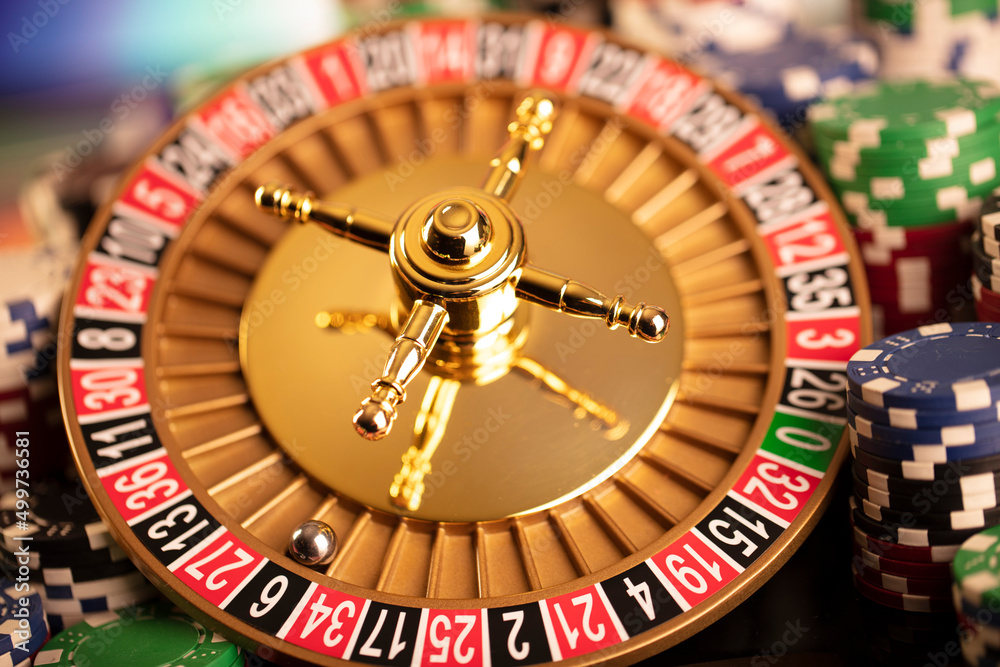 Casino theme. Gambling games. Roulette and poker chips on a colorful bokeh background. Casino theme. Gambling games. Roulette and poker chips on a colorful bokeh background.