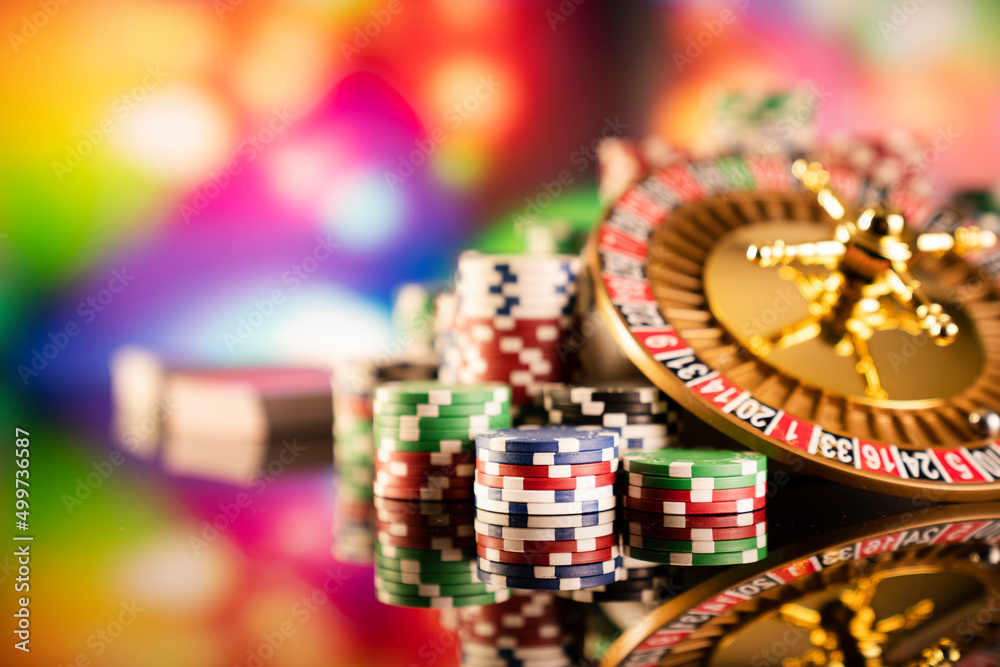 Casino theme.  Gambling games. Roulette and poker chips on a colorful bokeh background.