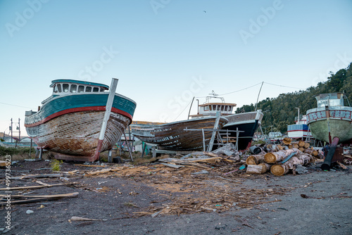 Obraz na plátně Front view of several boats under construction and abandoned near the beach in Lebu, Chile