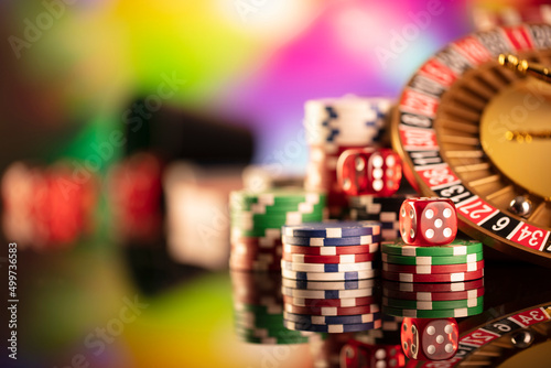 Casino theme. Gambling games. Roulette and poker chips on a colorful bokeh background.