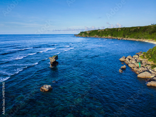 晴れた日の沖縄県南部の青い運みの海岸線の空撮風景