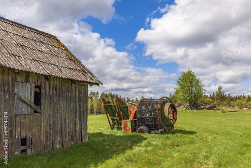 Old wooden barn with a potato picker