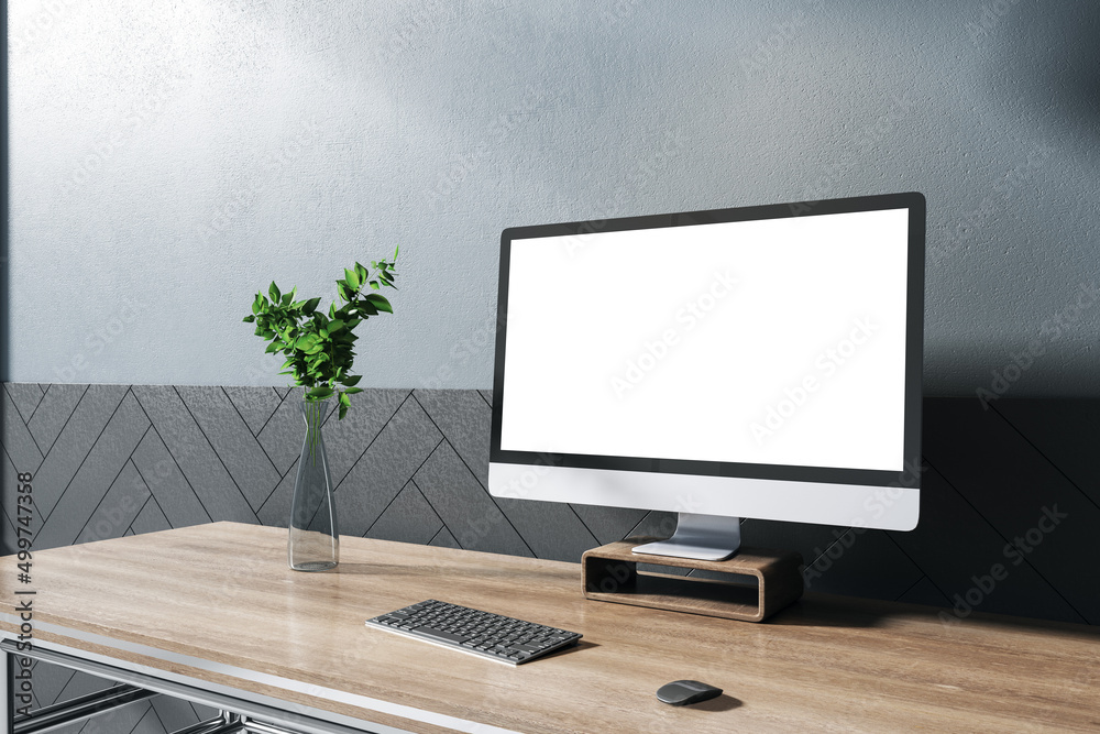 Fototapeta premium Modern designer wooden desktop with empty white computer screen, decorative plant, chair and concrete wall background. Mock up, 3D Rendering.
