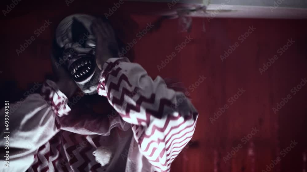 Portrait of a scary psychopath clown. A gloomy room, a place of terrible crimes
