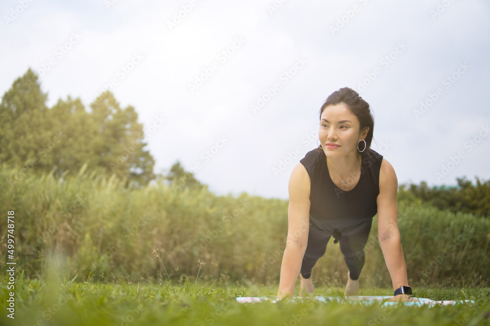 Asian women doing yoga exercise and relax in park, healthy lifestyle concept