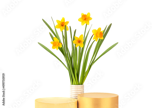 Two cylinder podiums and bouquet of daffodils flowers in a ceramic vase on a white background isolated, front view. Empty showcase for product presentation, pedestal for cosmetic product.