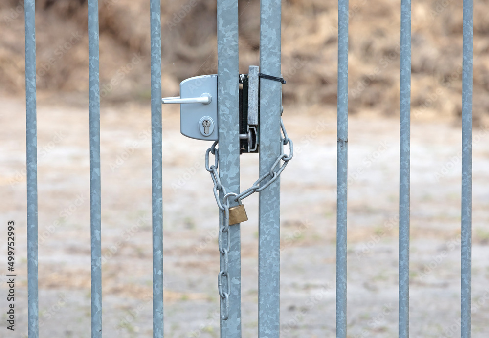 Large metal fence locked with a padlock and a chain Large metal fence locked with a padlock and a chain