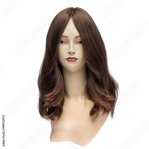 Natural hair wig on a mannequin on a white isolated background. Brunette, long wavy hair. Front view