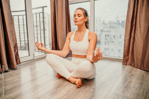 Young woman meditating at home. Girl practicing yoga in class. Relaxation at home, body care, balance, healthy lifestyle, meditation, mindfulness, recreation, workout, fitness, training concept