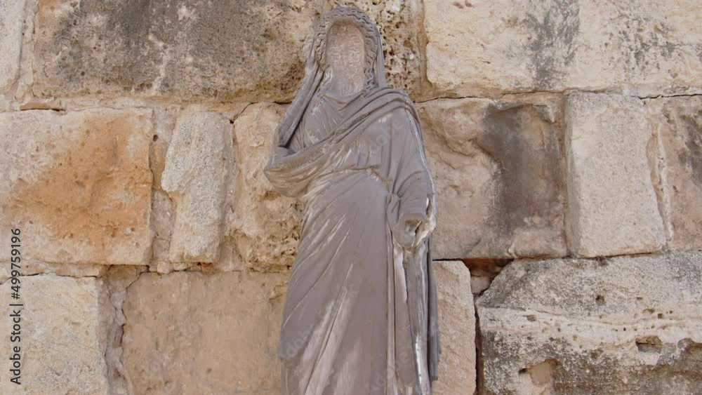 Religion statue near ruins of Salamis in Cyprus. Ancient stone wall. Motion view Religion statue near ruins of Salamis in Cyprus. Ancient stone wall. Motion view