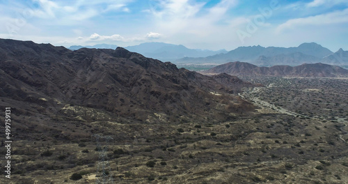 arid mountains in them you can see power towers and highways.