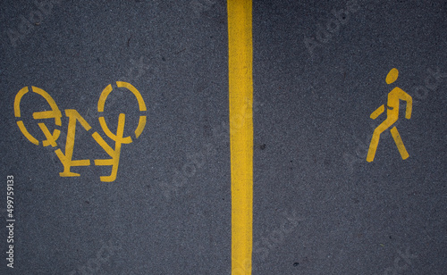 yellow road markings on asphalt, separate path for pedestrians and bicycles