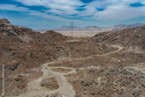 arid mountains in them you can see power towers and highways.