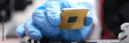 Repairman installing computer processor into motherboard closeup