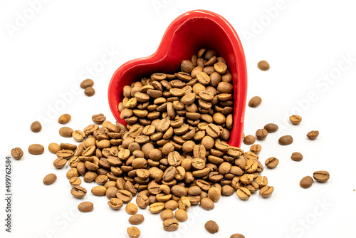 Coffee beans isolated on a white background. Full of coffee beans in a heart shaped plate. Close-up.