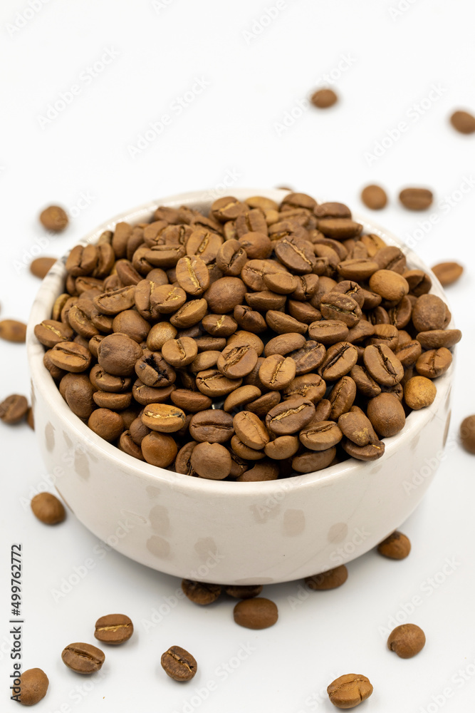 Coffee beans isolated on a white background. Full of coffee beans in a marble plate. Close-up. Coffee beans isolated on a white background. Full of coffee beans in a marble plate. Close-up.