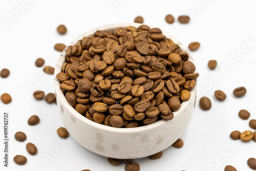 Coffee beans isolated on a white background. Full of coffee beans in a marble plate. Close-up.