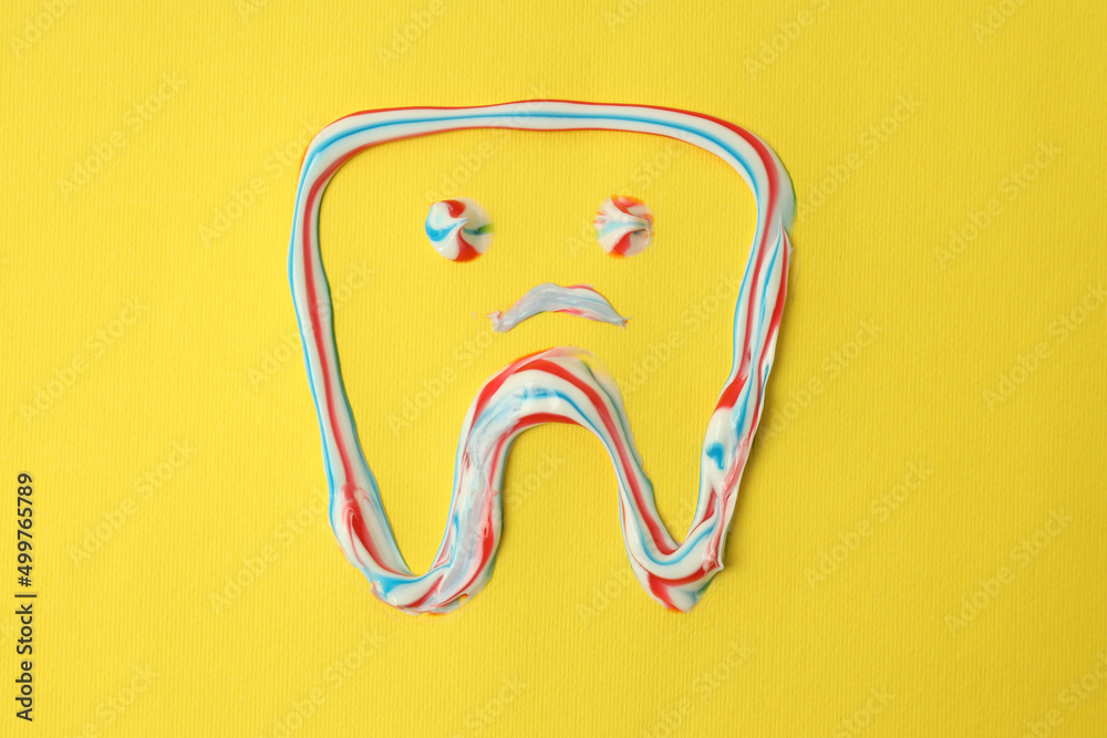 Tooth drawn with toothpaste on a yellow background Tooth drawn with toothpaste on a yellow background