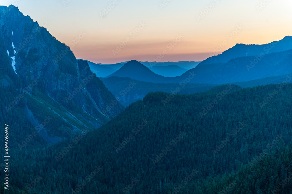 Obraz premium A glowing red sky illuminating the mountain slopes of Mount Rainier, as seen from the Paradise Area