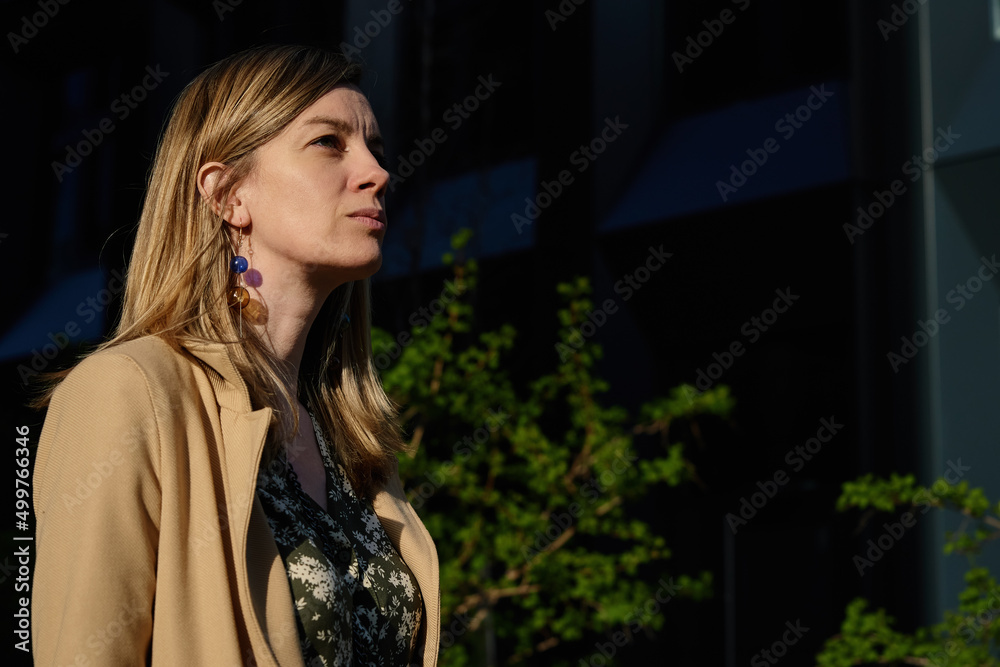 Portrait of millennial caucasian woman enjoying with sunny day outdoors, Female tourist wearing stylish trench walking at european city street Portrait of millennial caucasian woman enjoying with sunny day outdoors, Female tourist wearing stylish trench walking at european city street