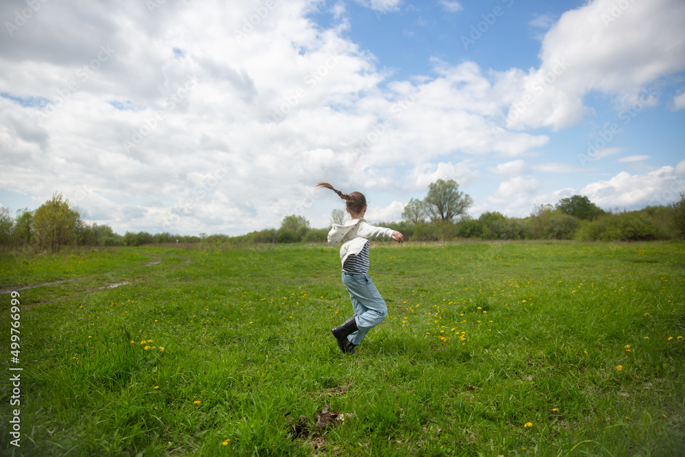 Girl child spins and dances in a large clearing in the forest, happy childhood and freedom in nature Girl child spins and dances in a large clearing in the forest, happy childhood and freedom in nature