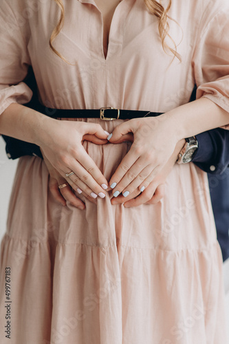 couple holding hands on pregnant belly © Юлия Чернецкая