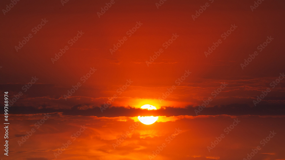 The sun is in a bloody sky with clouds. Abstract dark red sky background. Dramatic red sky. Red sunset with clouds. Fantastic sunset background with copy space for design. The end of the world