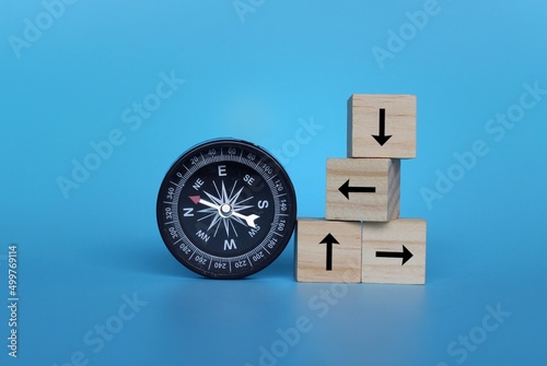 Fotobehang Compass and wooden cubes with arrow on blue background