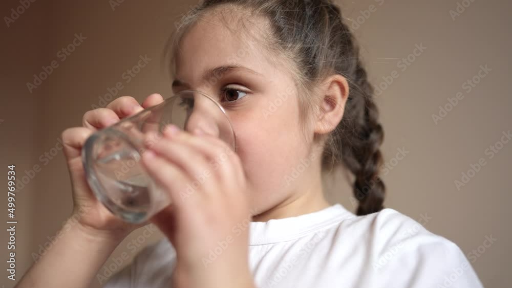 child drinking water. little girl in the kitchen lifestyle drinks water from a glass cup. problem of shortage of drinking water in the world concept. kid drinking clean water from a glass child drinking water. little girl in the kitchen lifestyle drinks water from a glass cup. problem of shortage of drinking water in the world concept. kid drinking clean water from a glass