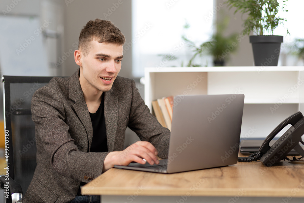 young handsome manager working in the office on a laptop young handsome manager working in the office on a laptop