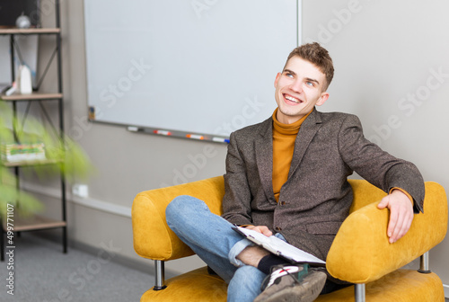 handsome young man smiling at camera and filling out forms photo